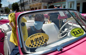 Conductor de un taxi privado limpia su automóvil en La Habana, el 19 de marzo de 2020