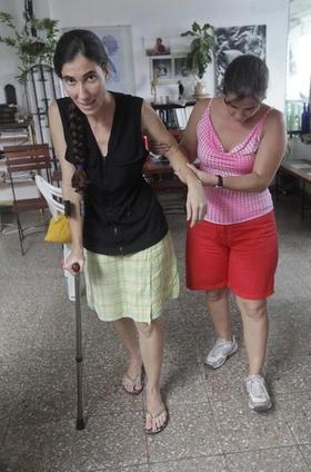 Yoani Sánchez (I) camina ayudada por una amiga y una muleta tras la golpiza que recibió el viernes. La Habana, 9 de noviembre de 2009. (REUTERS)