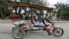 Un cubano transporta un cerdo en su triciclo-taxi, en Sagua La Grande, Cuba