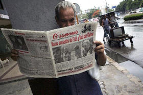 Un cubano lee el periódico oficial Granma, en cuya portada aparecen fotos de Fidel Castro, su hermano Raúl y el presidente de Venezuela, Hugo Chávez