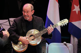 Silvio Rodríguez muestra una guitarra fabricada con material reciclado que le regaló el músico paraguayo Fabio Chávez, en la ceremonia en la que fue nombrado 'ciudadano ilustre' de Asunción. Paraguay, 30 de julio de 2009. (AP)