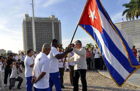 El primer vicepresidente del Consejo de Estado cubano, Miguel Díaz-Canel Bermúdez (centro derecha ), entrega al pentacampeón mundial, Mijaín López (centro izquierda), la bandera nacional que acompañó a la delegación de la Isla durante los XVII Juegos Panamericanos en Toronto, Canadá