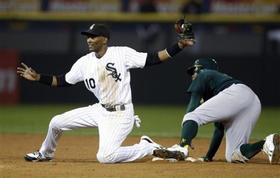 Alexei Ramírez, de los Medias Blancas de Chicago, durante un juego contra los Atléticos de Oakland. A su derecha, Rajai Davis. Chicago, 9 de septiembre de 2009. (AP)