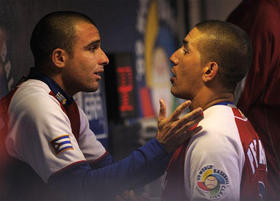 El catcher Ariel Pestano (dcha.) habla al pitcher Yulieski González, durante el juego con Japón del II Clásico Mundial, en San Diego, el 18 de marzo de 2009. (AP)