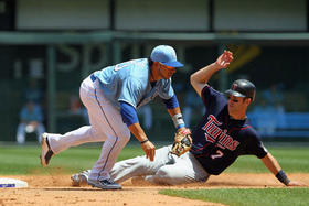 Mike Avilés (1), el número 30 por los Reales de Kansas City, y Joe Mauer (d), número 7 por los Mellizos de Minnesota, en esta imagen del 10 de julio de 2010