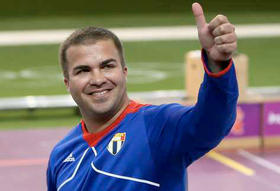 Leuris Pupo celebra en el podio su medalla de oro en prueba de tiro de pistola en velocidad 25 metros. Londres, 3 de agosto de 2012. (AFP)