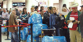 Cubanos esperan en el Aeropuerto de Miami para viajar a la Isla. (AP)
