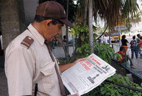 Un guardia de seguridad lee una 'reflexión' de Fidel Castro. (AP)