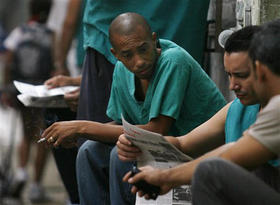 Cubanos leen el diario oficialista 'Granma' en una calle de La Habana