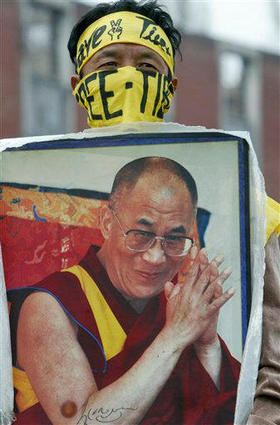Un tibetano en el exilio muestra la foto del Dalai Lama durante una manifestación