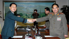El representante surcoreano Moon Sung-mook (izq.) estrecha la mano de su contraparte norcoreano Pak Rim Su