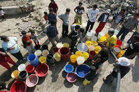 Sobrevivientes del terremoto de Perú llenan de agua envases plásticos. (AP)
