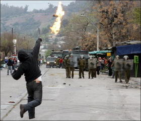 Un manifestante lanza un cóctel molotov contra la policía durante el aniversario 33 del golpe militar que llevó al poder a Pinochet. (YAHOO) Manifestaciones en Chile