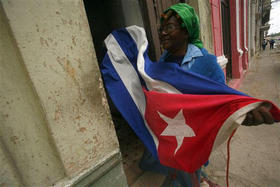 Habanera que recoge una bandera cubana para evitar que se la lleve el viento