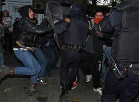 Un grupo de jóvenes, denominados 'antifascistas', se enfrenta a la policía española durante una concentración no autorizada en Madrid. (EL PAÍS)