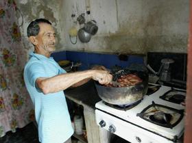 Un jubilado tostando maní para su venta ambulante