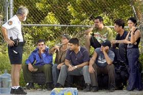 Un policía de Marco Island habla con siete de los 20 indocumentados cubanos que tocaron tierra. (AP) Emigrantes