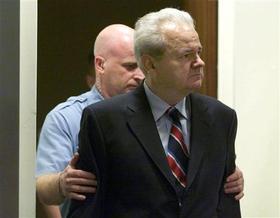 El ex presidente Milosevic, custodiado por un policía, durante uno de los juicios en La Haya