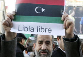 Un manifestante sostiene una pancarta durante una concentración en Madrid en solidaridad con las protestas en Libia, el 27 de febrero de 2011