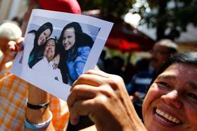 Una simpatizante del presidente Hugo Chávez sostiene una de las fotografías tomadas en La Habana, donde éste aparece con sus dos hijas