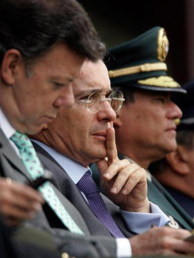 El presidente de Colombia, Álvaro Uribe (centro), junto al ministro de Defensa (izq.), durante una ceremonia con nuevos policías, el 12 de noviembre. (AP)