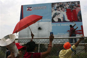 Simpatizantes de Chávez pintan de rojo una imagen del opositor Rosales, luego que el ejército tomara el control del puerto de Maracaibo, el 21 de marzo de 2009. (AP)