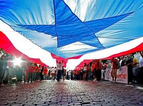 La bandera de Puerto Rico sostenida por participantes, durante un acto en San Juan, en esta foto de archivo