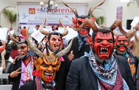 Simpatizantes portan máscaras de demonios en un mitin de Andrés Manuel López Obrador en Baja California