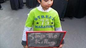 Un niño porta un cartel con el letrero “no más asesinatos” durante una manifestación contra el Gobierno en Daraya, Siria