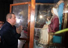 El mandatario venezolano, Hugo Chávez, junto a la imagen de la patrona del país, la Virgen Coromoto, en esta foto del 6 de enero