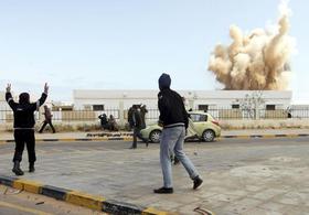 Rebeldes libios observan como las fuerzas leales a Muamar el Gadafi bombardean sus posiciones en Ras Lanuf, Libia