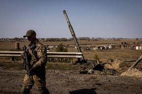 Un soldado ucraniano junto a un tanque ruso destruido