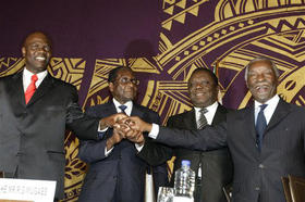 De izq. a dcha.: Mutmbara, Mugabe, Tsvangirai y Mbeki, durante la firma del acuerdo en Harare, el 15 de septiembre de 2008. (AP)