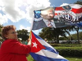 Emilia García de los Ríos ondea una bandera de Cuba y una bandera con la imagen del presidente Trump durante una manifestación en el Tropical Park el 4 de marzo de 2016 en Miami