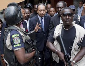 El ex dictador Jean-Claude Duvalier es escoltado por miembros de la policía haitiana fuera del hotel donde se alojaba en Puerto Príncipe