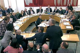 Un manifestante ataca con una sustancia blanca al jefe de News Corp, Rupert Murdoch, durante una audiencia ante una comisión en el Parlamento británico por el escándalo de las escuchas 