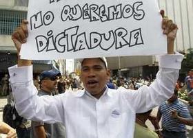 Un manifestante eleva un cartel en una protesta contra las últimas medidas del gobierno venezolano. Un manifestante eleva un cartel en una protesta contra las últimas medidas del gobierno venezolano