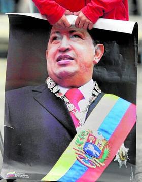 Un niño sujeta un cartel con la imagen de Hugo Chávez. Un niño sujeta un cartel con la imagen de Hugo Chávez