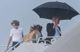 La primera dama y Barron Trump, sin paraguas, detrás del presidente de EEUU