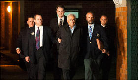 Dominique Strauss-Kahn, al centro, abandona una estación de policía de Nueva York para ser presentado en la Corte Criminal de Manhattan