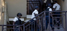 Varios policías suben por la escalera del hotel donde se encuentra alojado el ex dictador Duvalier en Puerto Príncipe