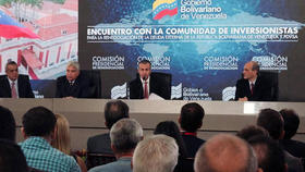 El vicepresidente venezolano Tareck El Aissami (centro) habla con inversionistas ayer, en Caracas, sobre las obligaciones de la deuda