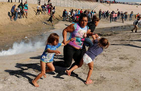 Migrantes huyen de los gases lacrimógenos en la frontera entre Estados Unidos y México