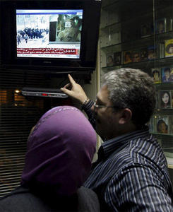 Una pareja sigue en televisión el discurso del lider Muamar el Gadafi en un local de Beirut, Líbano. En el discurso, el líder libio se ratificó en su intención de seguir en el poder