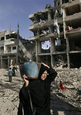 Una mujer palestina trata de salvar algunas pertenencias tras un bombardeo israelí. Ciudad de Gaza, 13 de enero de 2009. (AP)