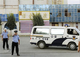Un policía gesticula a los fotógrafos cerca del sitio del atentando de Xinjiang.