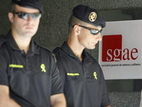 Agentes de la Guardia Civil custodian una de las puertas de la sede de la Sociedad General de Autores y Editores en Madrid. (EFE)