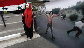 Una manifestante árabe sostiene una bandera siria junto a una foto de una protesta en Siria, en una manifestación en Sao Paulo, Brasil