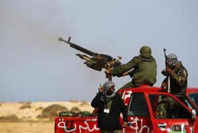 Combatientes rebeldes disparan contra las tropas de Gadafi cerca de Bin Jawad, en el este de Libia, el 29 de marzo de 2011