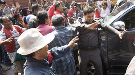 Policía intenta contener a seguidores del ex primer ministro que agreden el auto de un legislador. Bangkok, Tailandia, 15 de diciembre de 2008. (AP) Policía intenta contener a seguidores del ex primer ministro. Bangkok, Tailandia. (AP)
